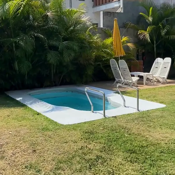 Jardín con alberca y camastros
