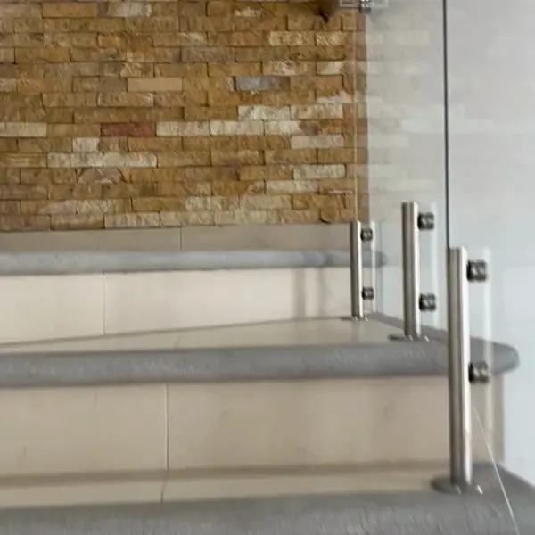 Baño con muro de piedra y cancel de vidrio