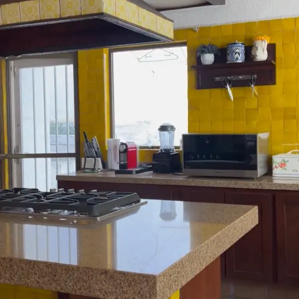 Cocina con barra de granito y azulejo amarillo